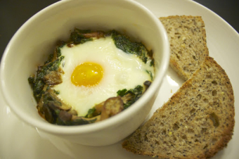 A supper best eaten standing: Baked eggs with kale, cream and mushrooms